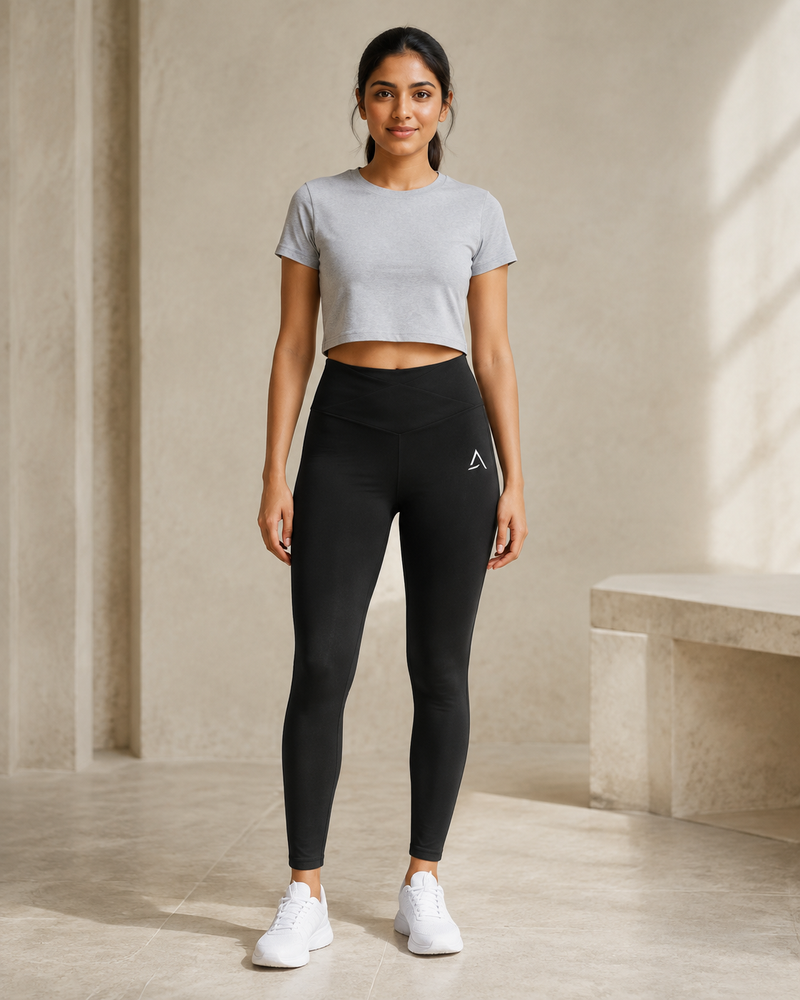 Self Made Club Form Legging in black on a female model in front view, showing cross-front waistband, left thigh mark and full-length fit. AI-generated styling visualization.