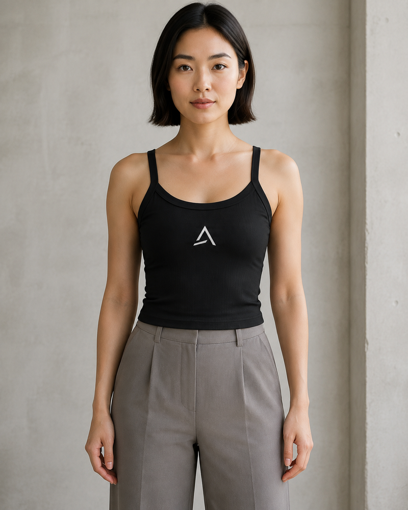 Self Made Club Form Rib Tank in black on a female model, showing narrow flat straps, scoop neckline, micro-rib fabric and centered embroidered mark. AI-generated styling visualization.