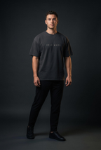 Male model wearing the Self Made Club Forged in Repetition Tee — front
