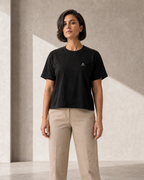 Self Made Club Form Box Tee in black on an alternate female model, full untucked front view showing the small left chest embroidery and boxy fit. AI-generated styling visualization.