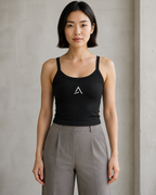Self Made Club Form Rib Tank in black on a female model, showing narrow flat straps, scoop neckline, micro-rib fabric and centered embroidered mark. AI-generated styling visualization.
