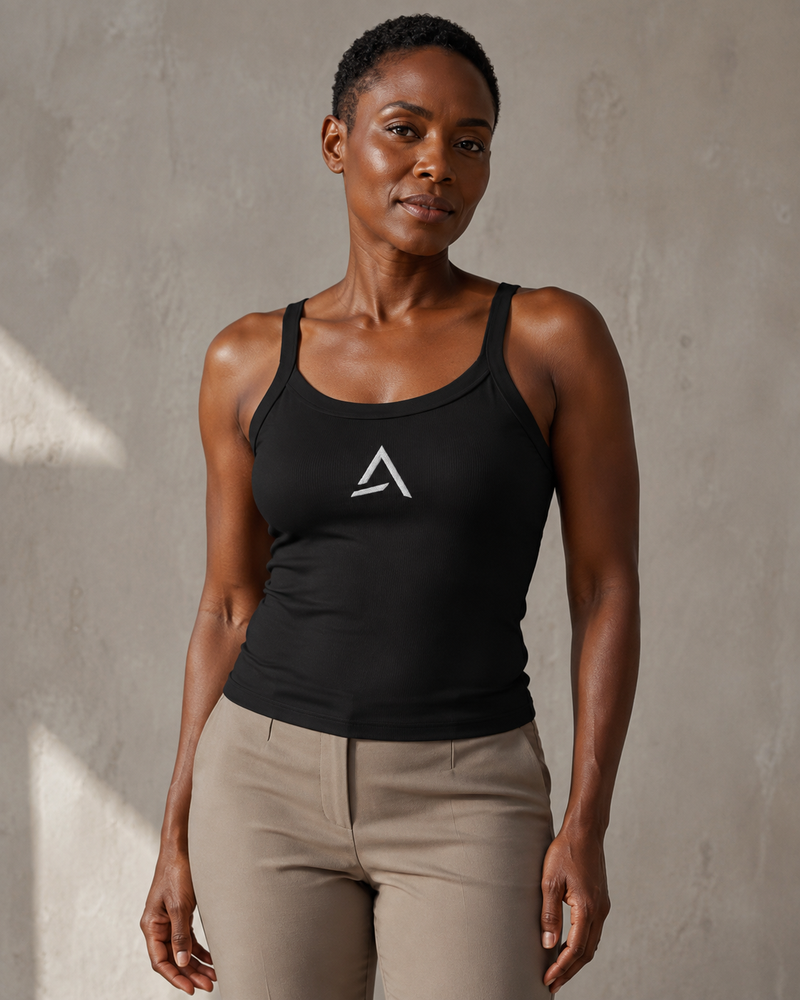 Self Made Club Form Rib Tank in black on a different female model, showing narrow flat straps, scoop neckline, micro-rib fabric and centered embroidered mark. AI-generated styling visualization.