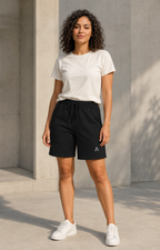 Self Made Club Sweat Shorts in black on an alternate female model, standing view showing waistband, pockets and full hems. AI-generated styling visualization.