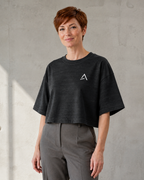 Self Made Club Washed Form Crop in black on a different female model in three-quarter view, showing left chest mark, washed black cotton and oversized cropped fit. AI-generated styling visualization.